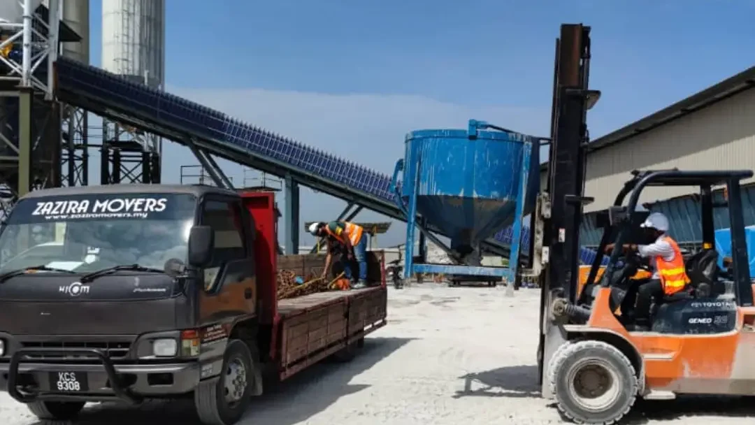 Logistics team loading labelled business stock into a transport lorry in Malaysia