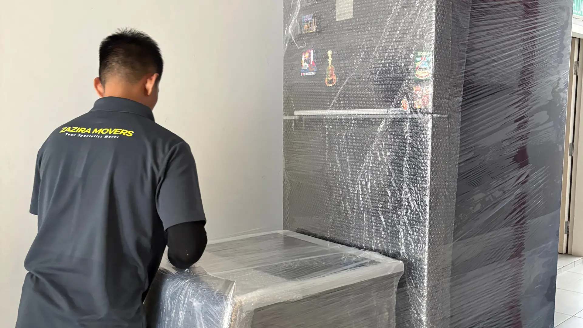Moving crew using bubble wrap to protect fragile furniture before transport