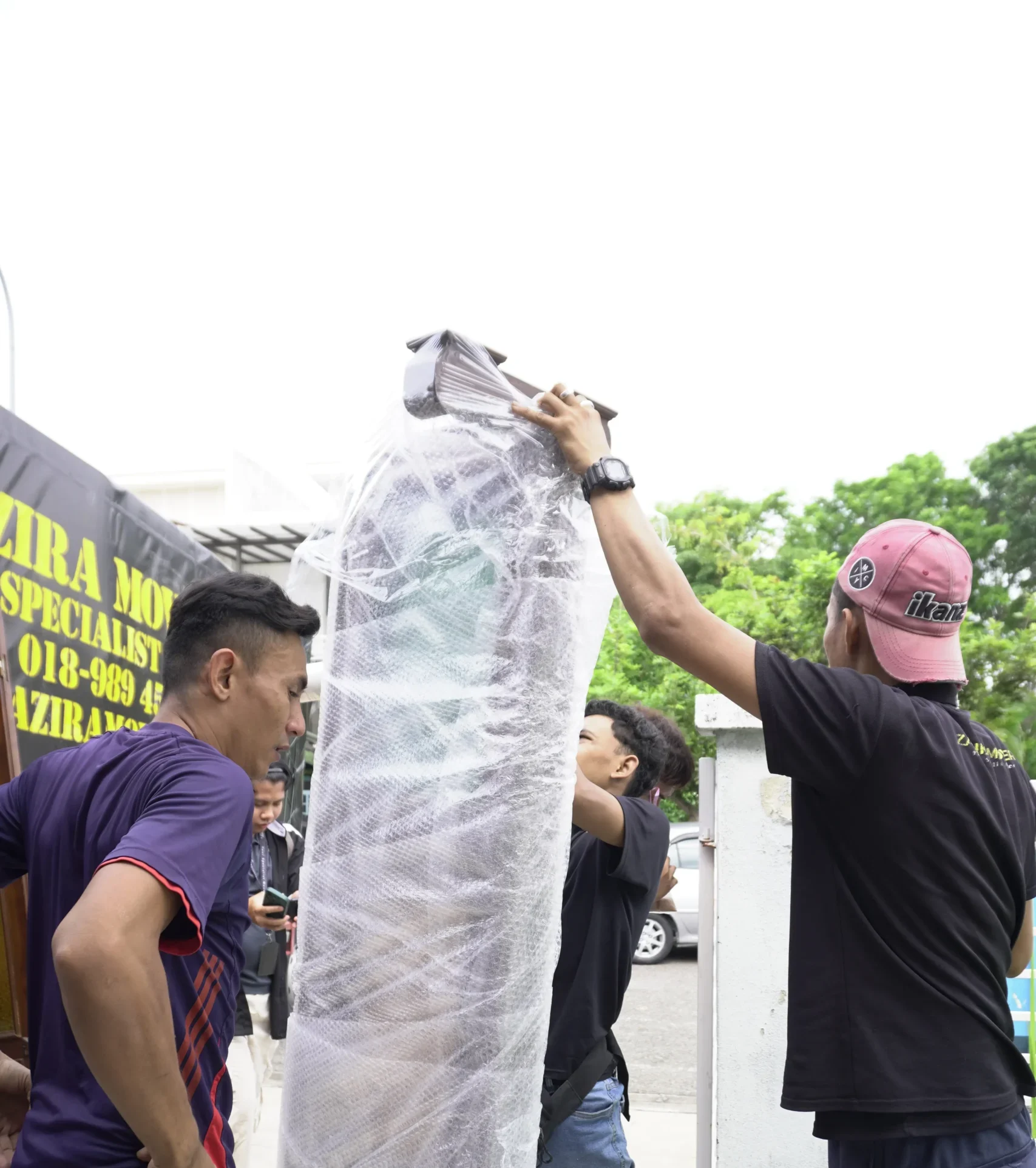 Packing crew protecting fragile items with bubble wrap and moving boxes scaled e1785203919956