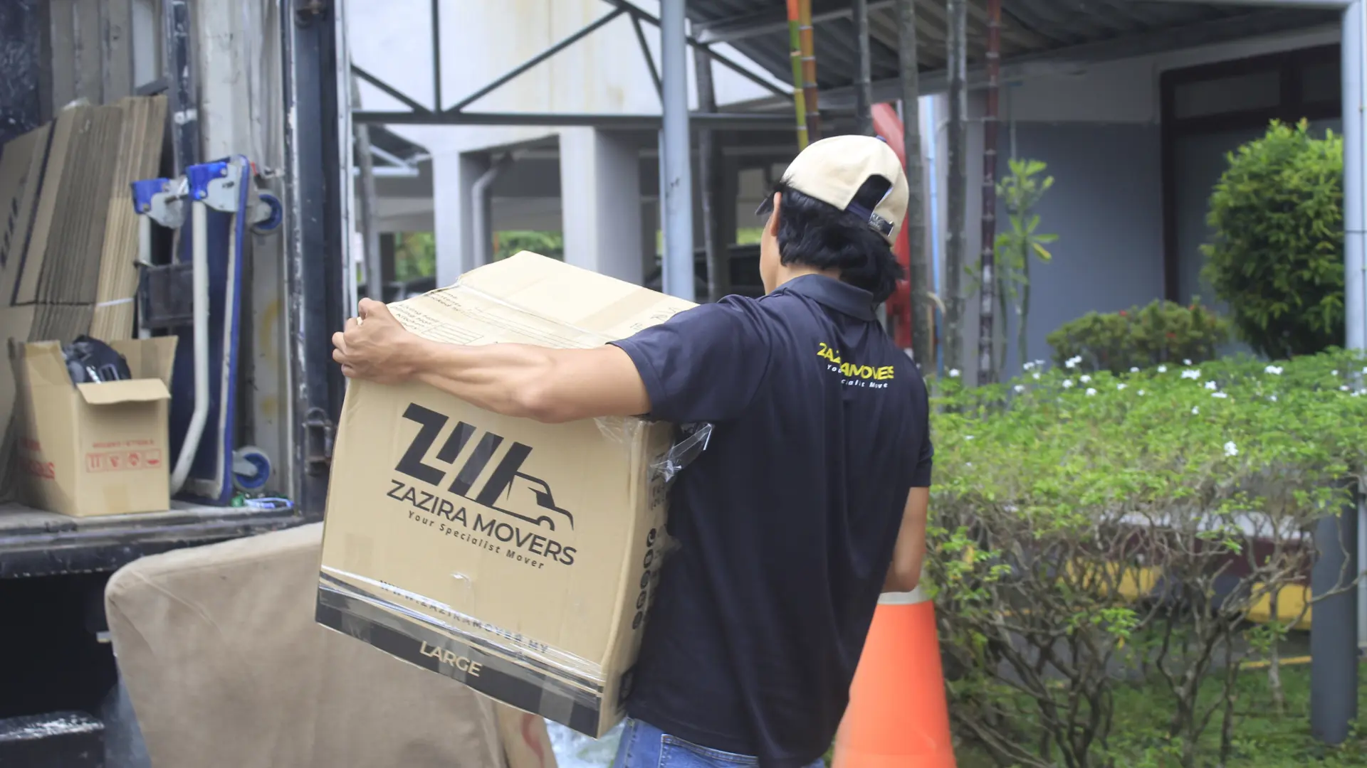 Movers in Penang 2 Professional movers carrying boxes during a house move