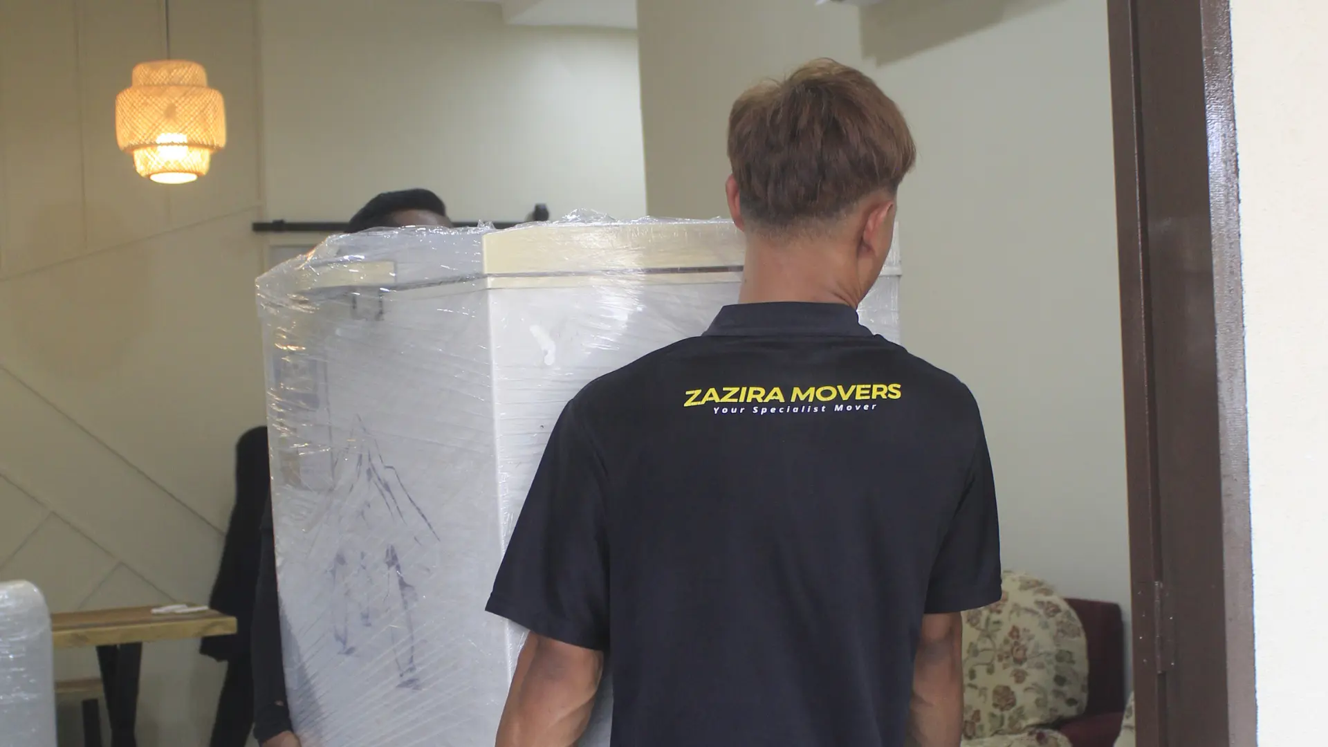 Movers in Johor Bahru 2 Professional movers carrying household furniture during a home move
