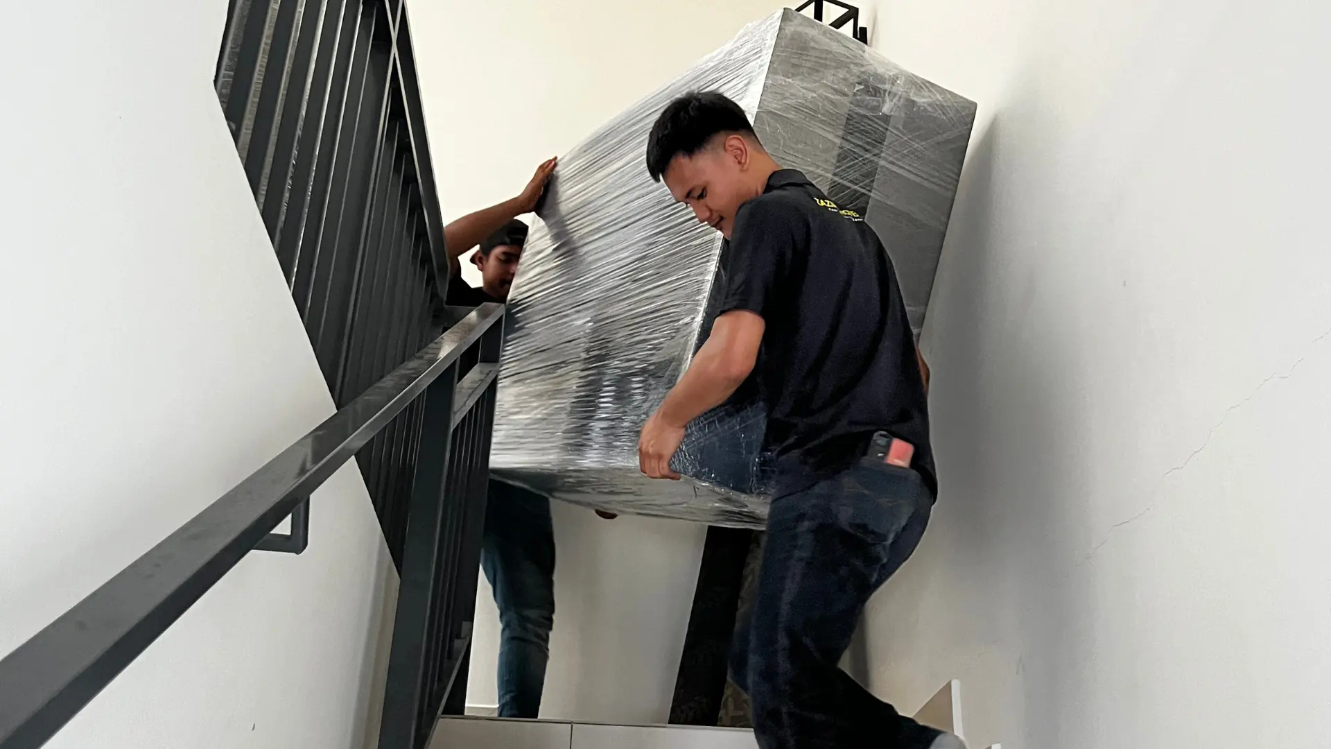 Zazira Movers crew carrying furniture through condominium access during a house move