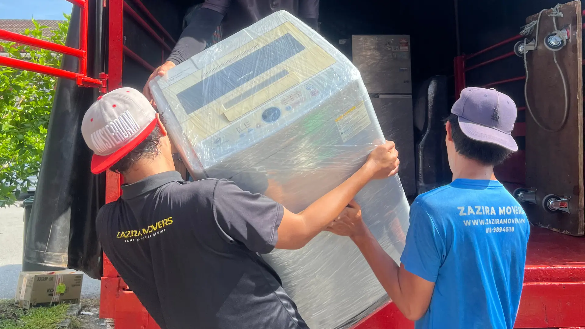 Zazira Movers crew loading household furniture into a moving lorry in Malaysia