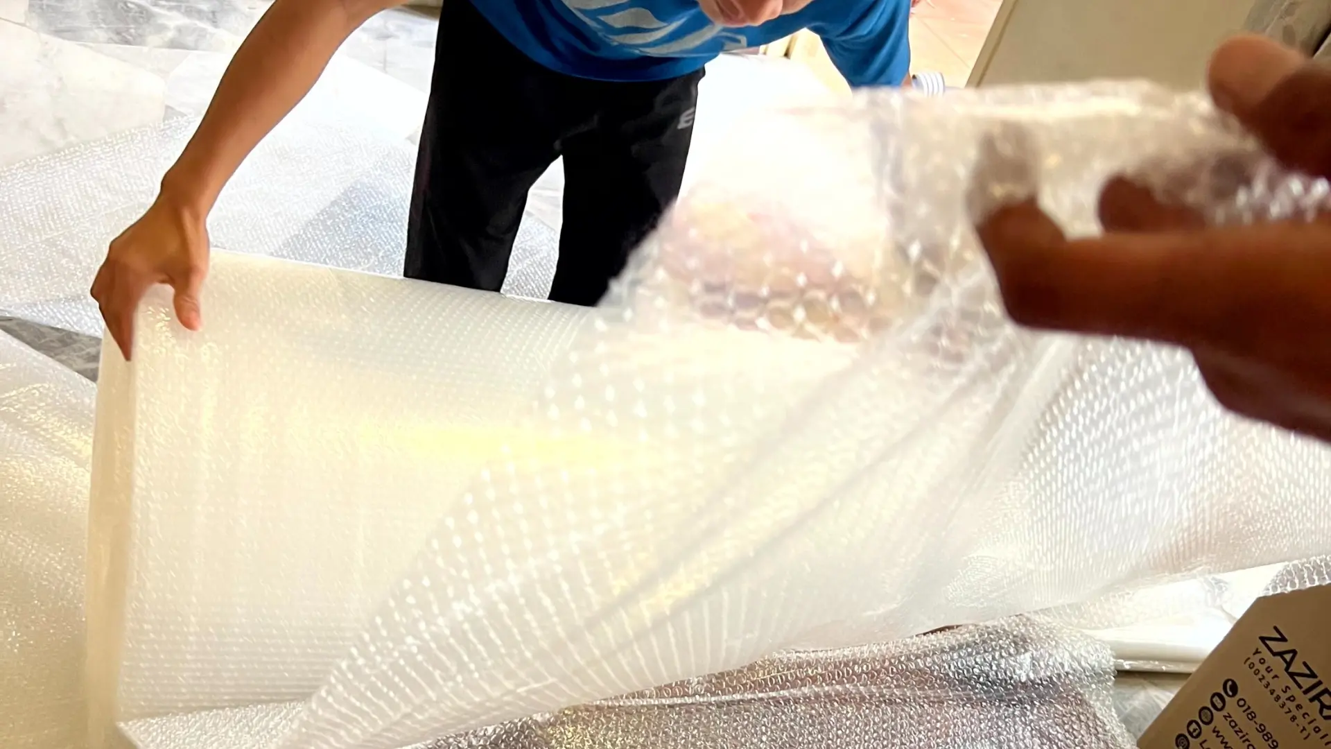 Zazira Movers crew wrapping furniture with bubble wrap for house moving