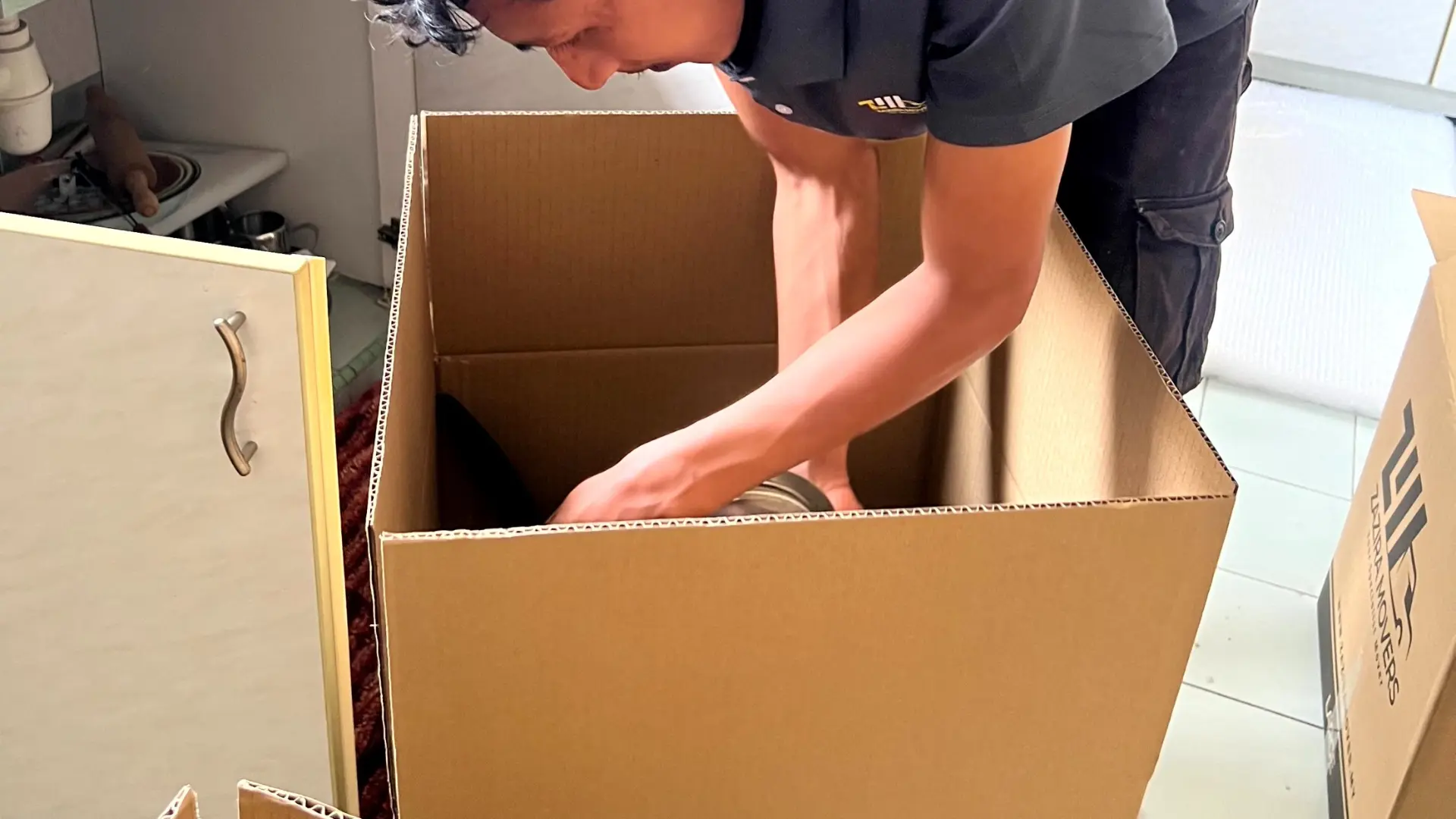 Zazira Movers team packing household items into labelled moving boxes